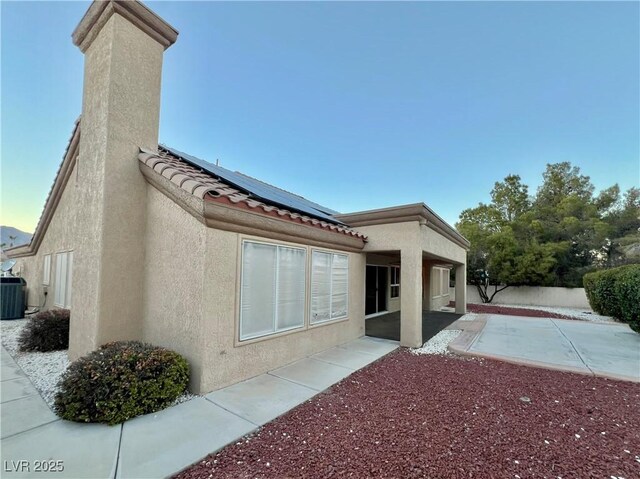 exterior space with solar panels, a patio area, and central air condition unit