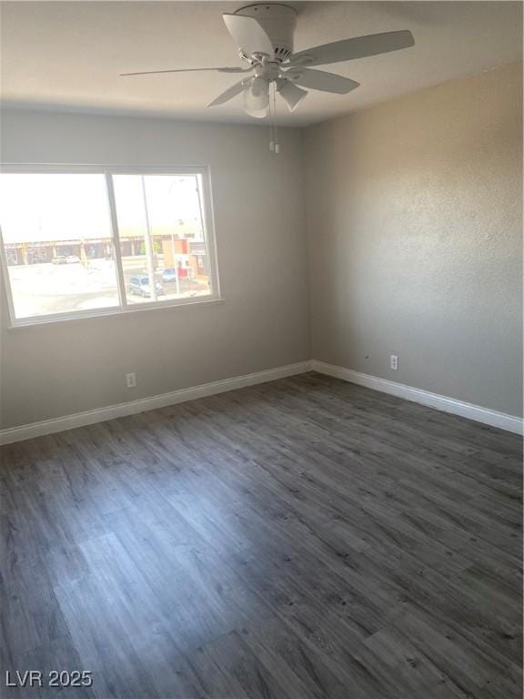 unfurnished room featuring ceiling fan and dark wood-type flooring