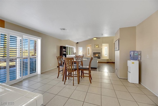 tiled dining space featuring vaulted ceiling and ceiling fan