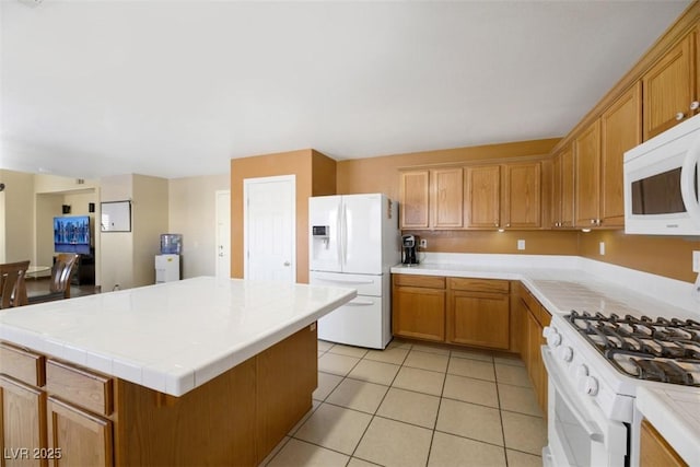 kitchen with a kitchen island, white appliances, and light tile patterned floors