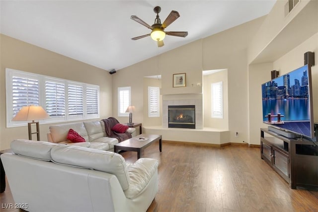 living room featuring a fireplace, hardwood / wood-style flooring, ceiling fan, and lofted ceiling