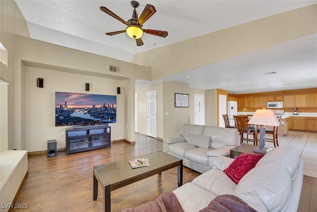 living room with ceiling fan and light hardwood / wood-style flooring