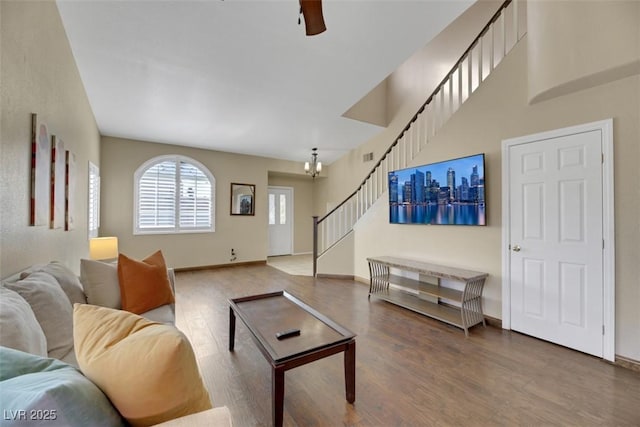 living room featuring wood-type flooring and ceiling fan with notable chandelier