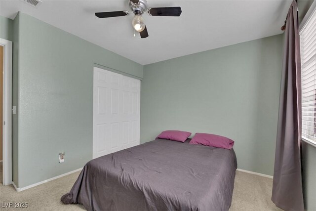 carpeted bedroom with ceiling fan and a closet