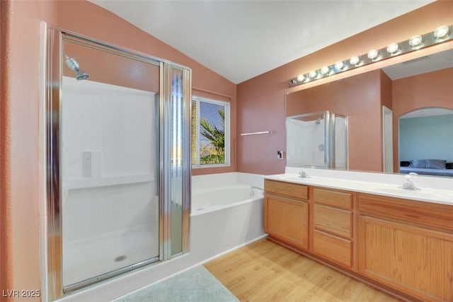 bathroom with hardwood / wood-style floors, separate shower and tub, lofted ceiling, and vanity