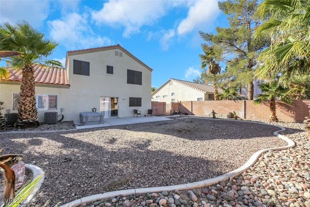 rear view of house with central air condition unit and a patio