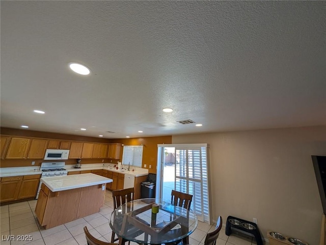 dining room with sink, a textured ceiling, and light tile patterned flooring