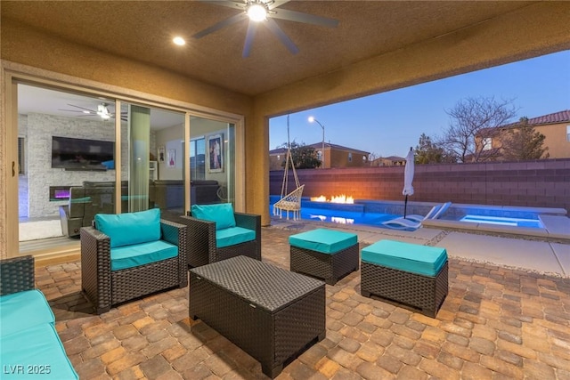 patio terrace at dusk with a pool with hot tub, an outdoor hangout area, and ceiling fan