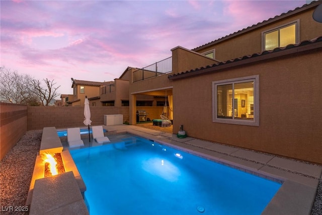 pool at dusk with a patio