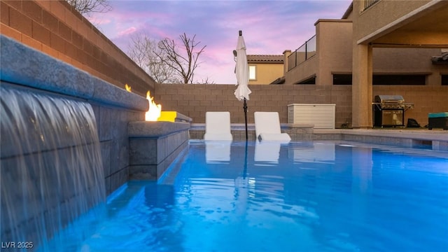 pool at dusk with a grill