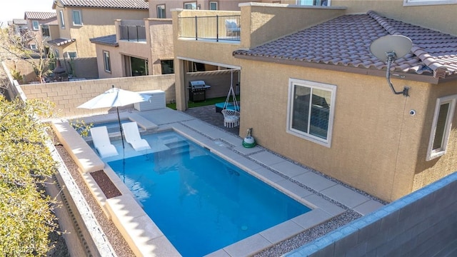 view of pool with a patio and a grill