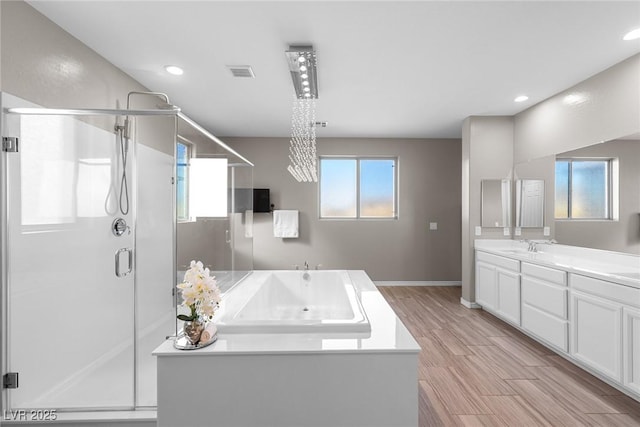 bathroom with wood-type flooring, independent shower and bath, and vanity