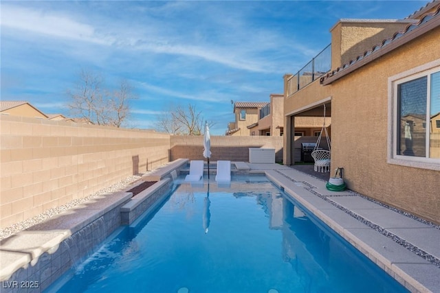 view of pool with pool water feature and area for grilling