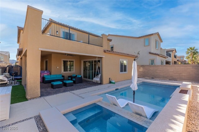 back of house with a balcony, a pool with hot tub, ceiling fan, an outdoor living space, and a patio