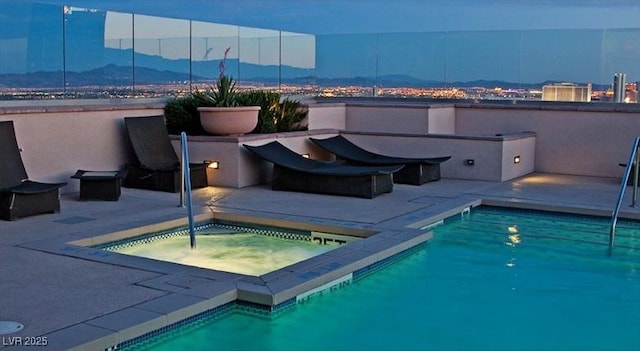 view of pool featuring an in ground hot tub, a mountain view, and a patio