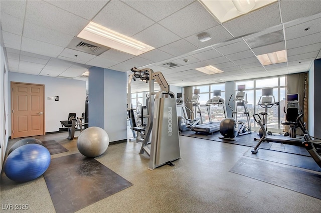 exercise room with a paneled ceiling and floor to ceiling windows