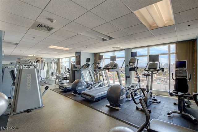 workout area featuring a drop ceiling and floor to ceiling windows