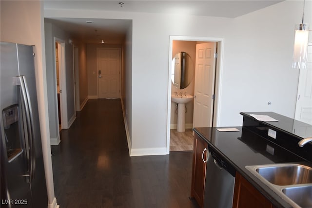 kitchen with appliances with stainless steel finishes, dark wood-type flooring, and sink