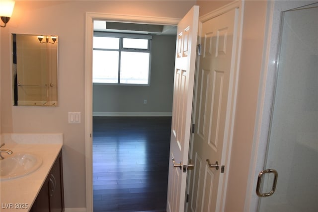 bathroom featuring hardwood / wood-style floors, vanity, and walk in shower