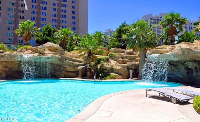 view of swimming pool with pool water feature