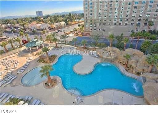 view of swimming pool with pool water feature and a patio