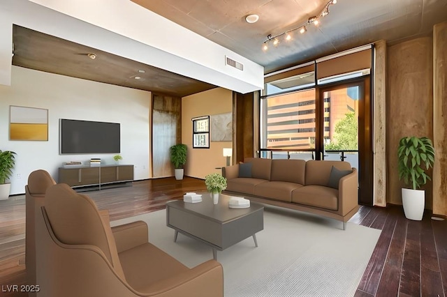 living room with dark hardwood / wood-style floors and track lighting