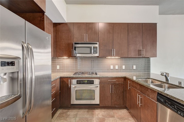 kitchen featuring sink, decorative backsplash, light tile patterned floors, appliances with stainless steel finishes, and light stone counters