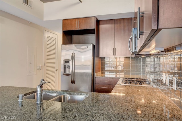 kitchen with sink, stone countertops, and appliances with stainless steel finishes