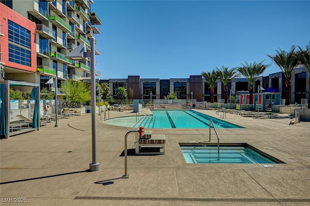 view of swimming pool with a patio and a hot tub