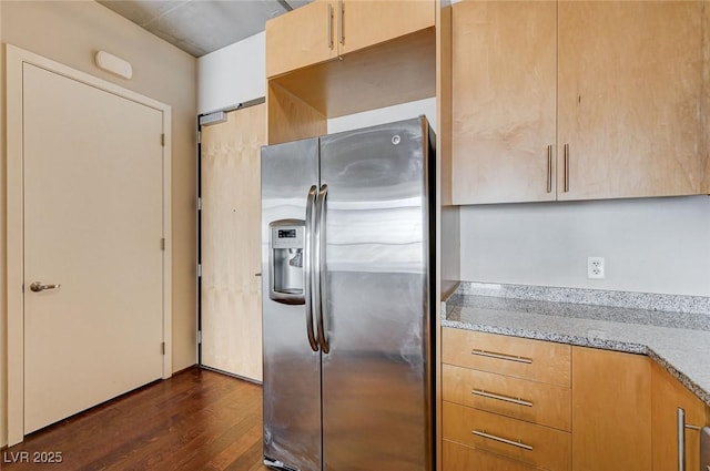 kitchen with light stone countertops, dark wood-type flooring, and stainless steel refrigerator with ice dispenser