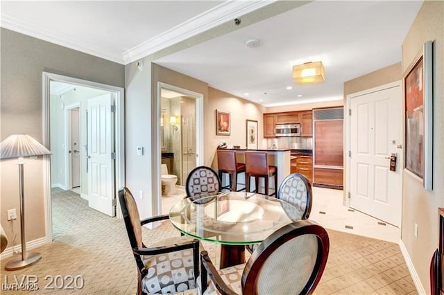 dining room featuring light carpet and crown molding