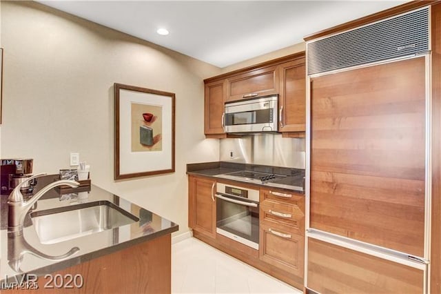 kitchen with light tile patterned floors, stainless steel appliances, and sink