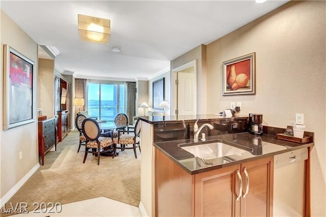 kitchen featuring kitchen peninsula, dishwasher, sink, and dark stone countertops