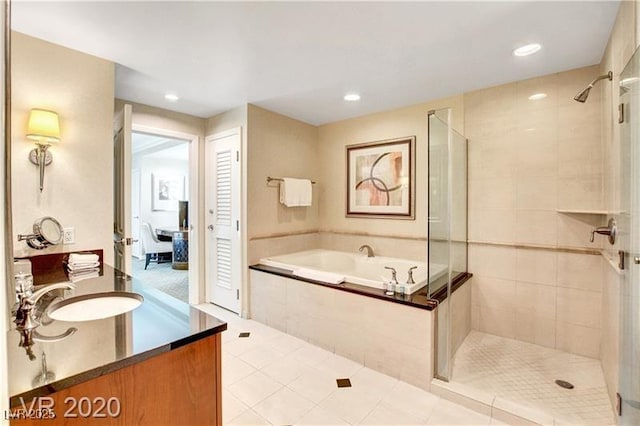 bathroom with vanity, tile patterned flooring, and plus walk in shower