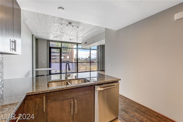 kitchen with floor to ceiling windows, dark wood-type flooring, sink, dark stone countertops, and dishwasher