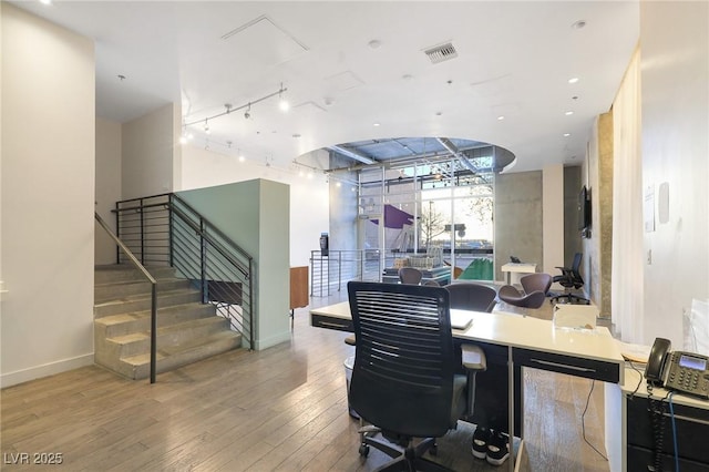 home office featuring rail lighting and hardwood / wood-style flooring