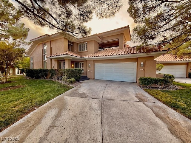 mediterranean / spanish home featuring a garage and a yard