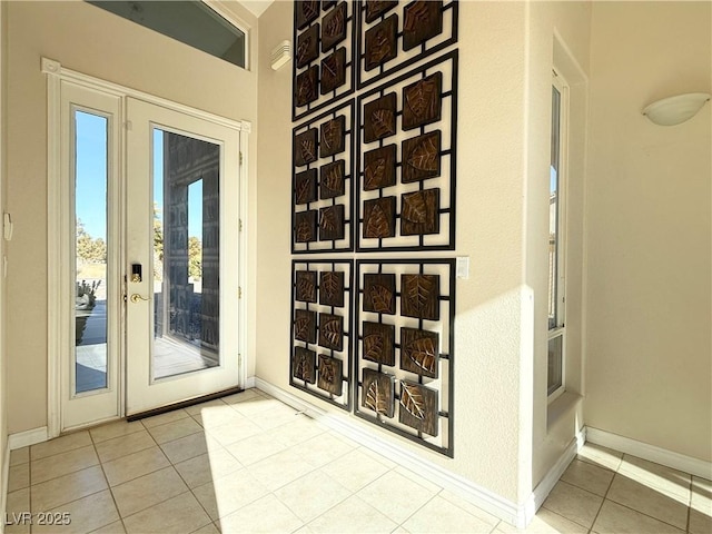 doorway to outside featuring light tile patterned flooring and a healthy amount of sunlight