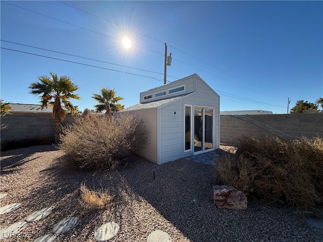 rear view of property with a storage unit