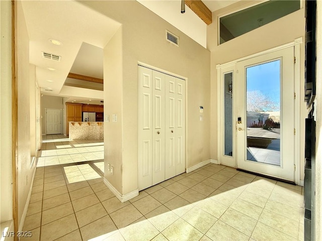 tiled foyer entrance featuring beamed ceiling