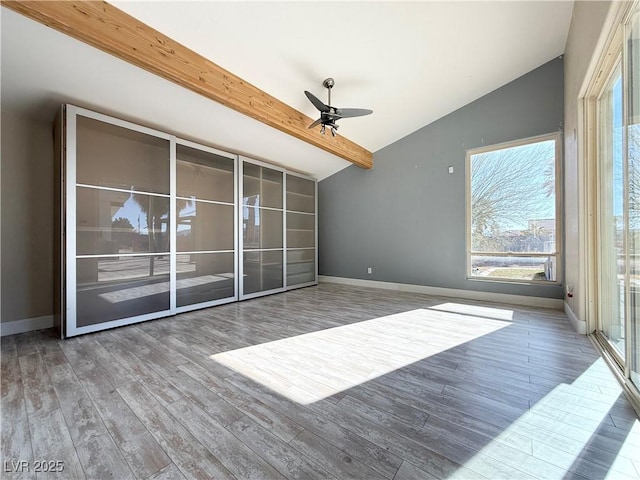 unfurnished living room with wood-type flooring, lofted ceiling with beams, and ceiling fan