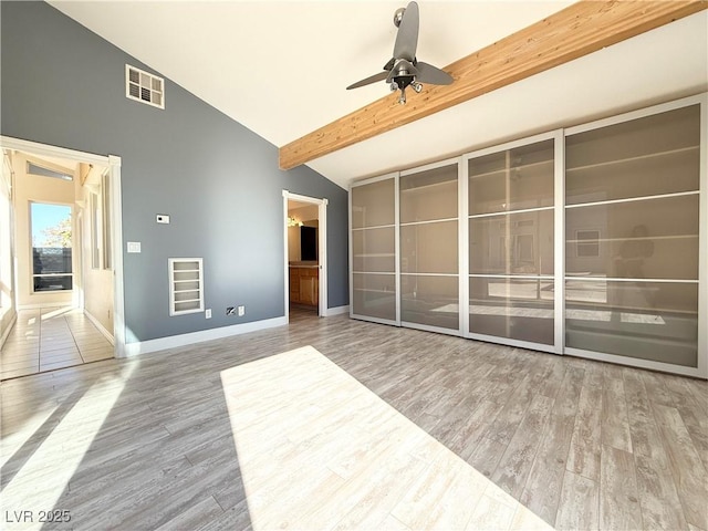 unfurnished room featuring vaulted ceiling with beams, ceiling fan, and wood-type flooring