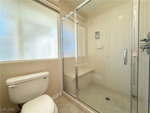 bathroom featuring tile patterned floors, an enclosed shower, and toilet