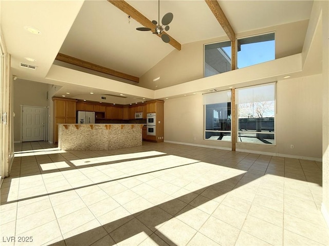 unfurnished living room featuring beam ceiling, ceiling fan, light tile patterned floors, and high vaulted ceiling