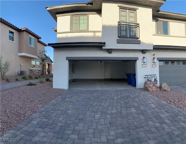 view of front facade featuring a garage and central air condition unit