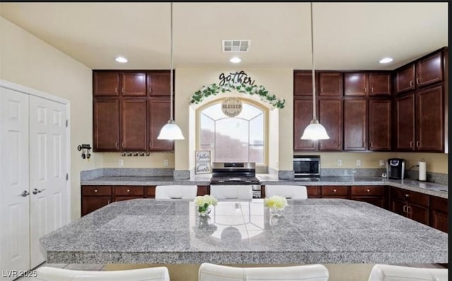 kitchen featuring a breakfast bar, stainless steel appliances, and hanging light fixtures