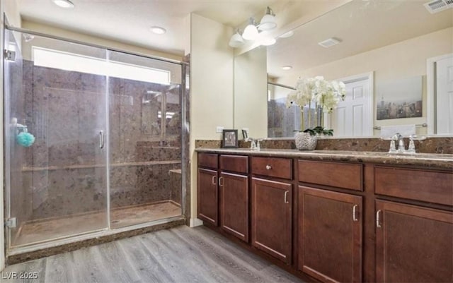 bathroom featuring vanity, hardwood / wood-style flooring, an enclosed shower, and ceiling fan