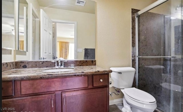 bathroom featuring vanity, toilet, and a shower with shower door