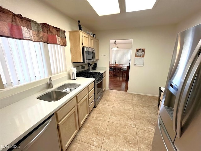 kitchen featuring pendant lighting, sink, light tile patterned floors, light brown cabinetry, and appliances with stainless steel finishes