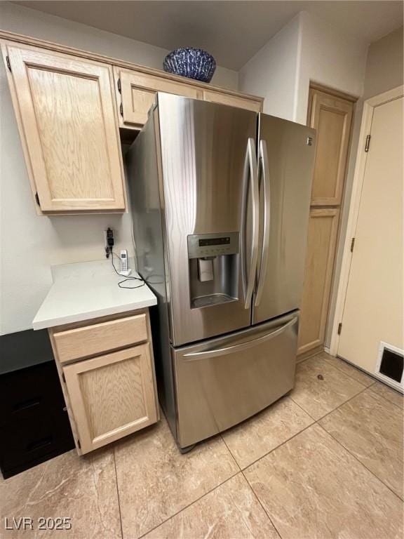 kitchen with light brown cabinets and stainless steel refrigerator with ice dispenser